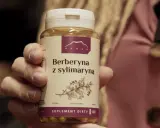 Dłoń trzyma opakowanie suplementu diety "Berberyna z sylimaryną". Nie jest to lek ani tabletki antykoncepcyjne.
