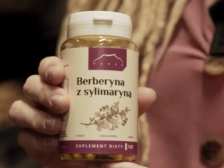 Dłoń trzyma opakowanie suplementu diety "Berberyna z sylimaryną". Nie jest to lek ani tabletki antykoncepcyjne.